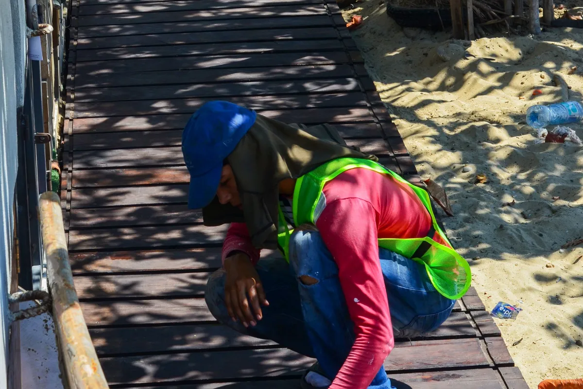 Ouvrier appliquant un produit de traitement sur une terrasse en bois