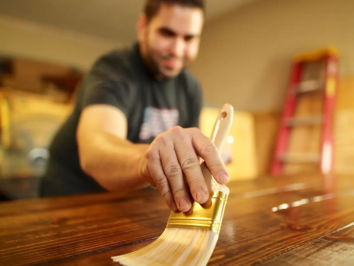 Entretien de terrasse en bois à La Colle-sur-Loup : artisan appliquant une protection sur du bois