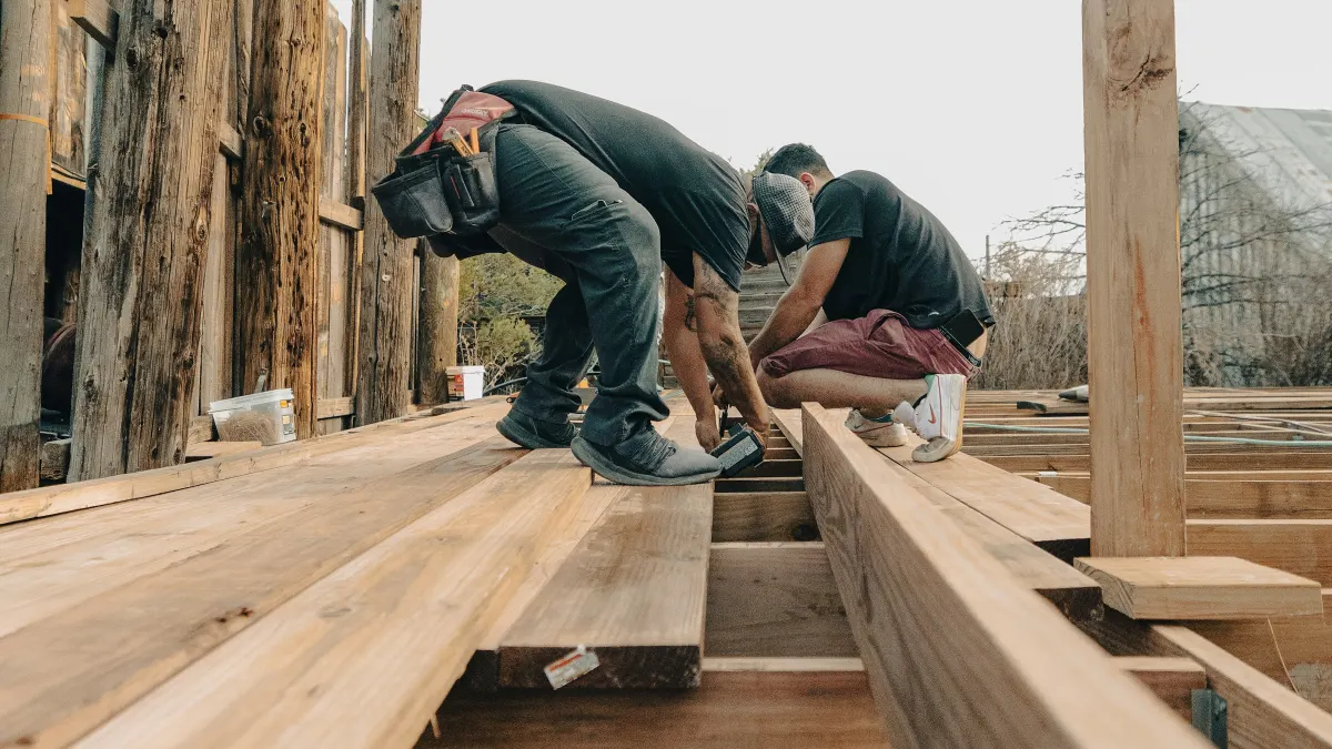 Artisans posant les lames d’une terrasse en bois sur son ossature