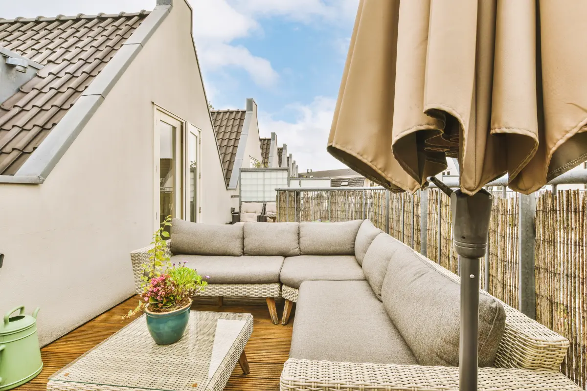 Terrasse en bois dans le village de La Colle-sur-Loup : terrasse en bois avec salon d’angle et parasol