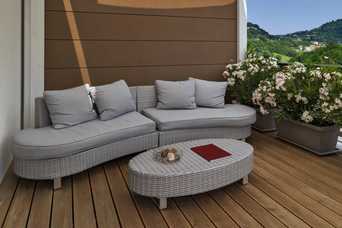Terrasse en bois aux Campons à La Colle-sur-Loup : canapé en rotin sur une terrasse en bois